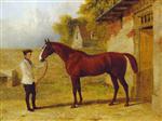 A chestnut Hunter held by a groom in a stable yard